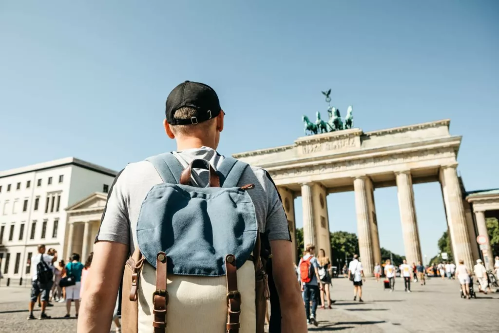 Mann vor dem Brandenburger Tor in Berlin, genießt dank deutscher Tourismusförderung.