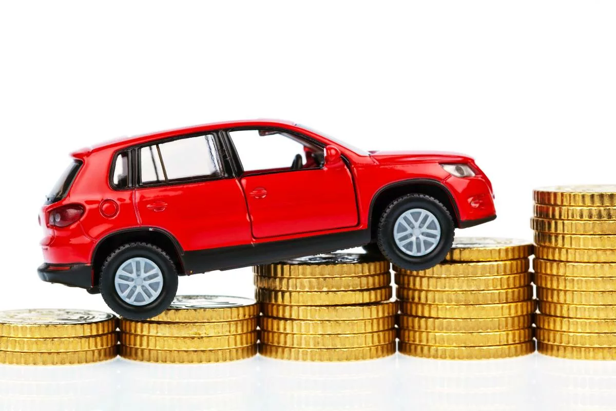 Rotes Auto auf Goldmünzen Kilometerpauschale verstehen für mehr Steuerabzüge