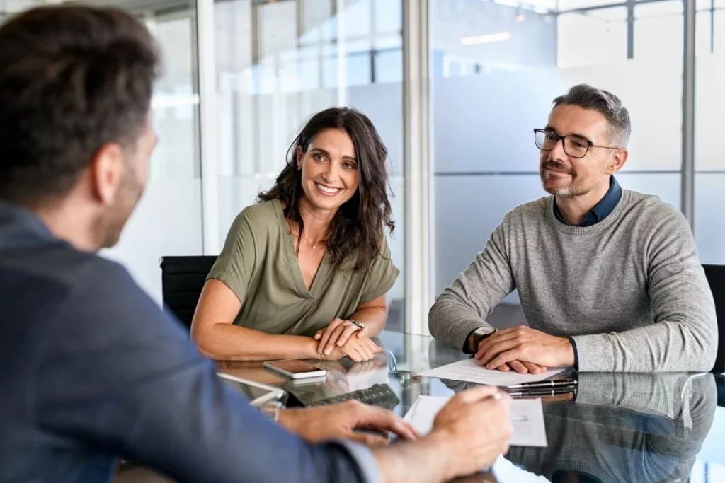 Geschäftsleute besprechen einen Kreditvertrag mit Unterstützung der BBB Bürgschaftsbank Bayern in einem modernen Büro