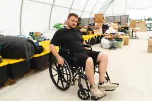 Mann im Rollstuhl in einem Lager für Kriegsopferfürsorge.